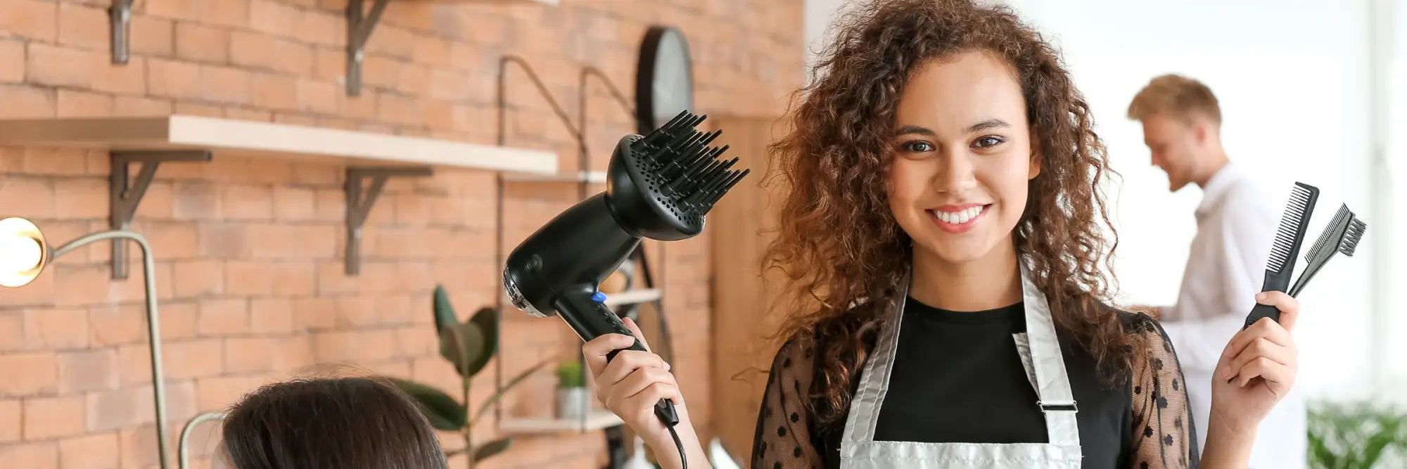 Friseurin hält Styling-Tools in der Kollektion Accessoires für Friseurbedarf