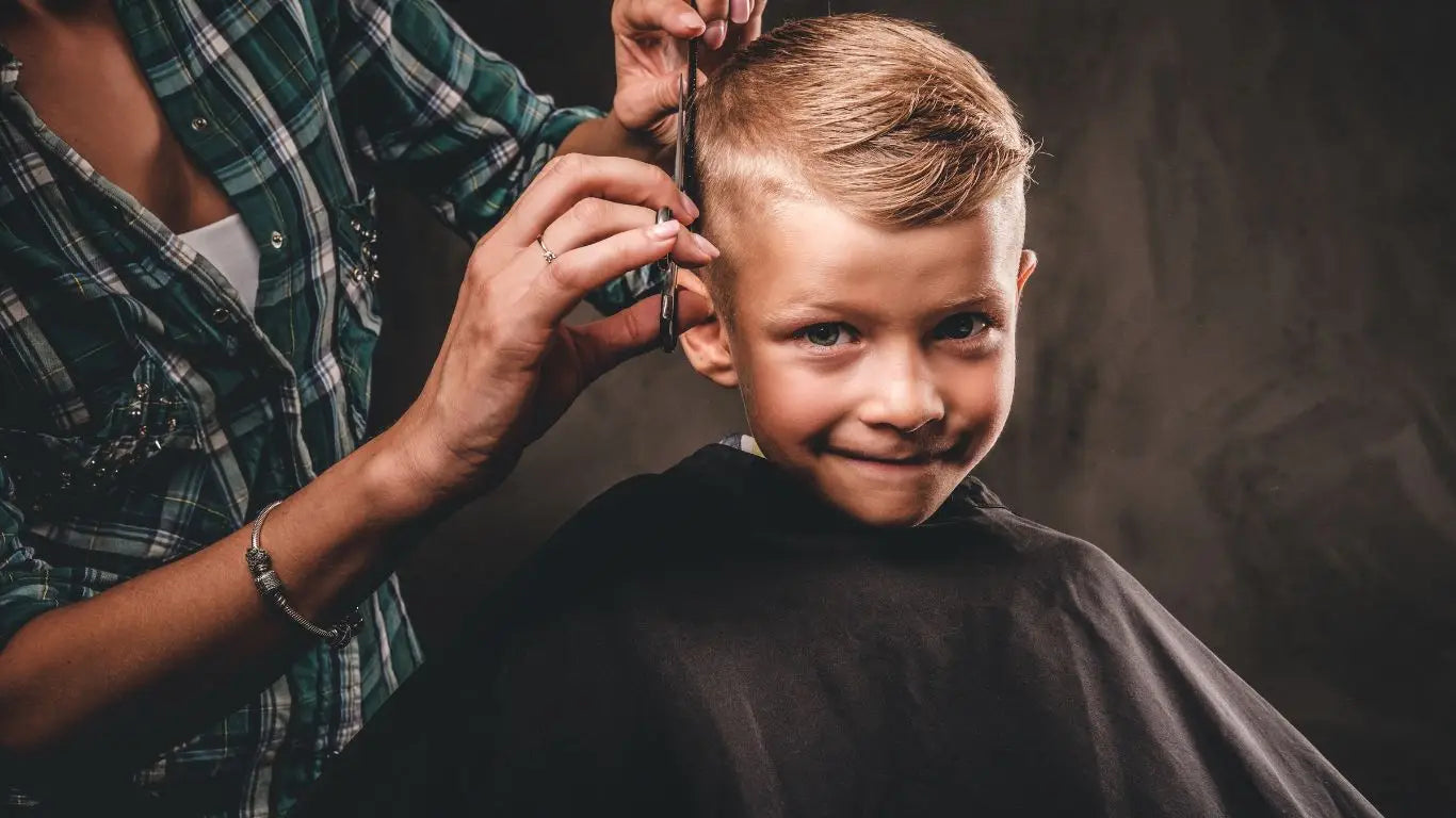 Junge bekommt eine Haarschnitt im Kinderfriseurstuhl in der Sammlung Friseurstühle für Kinder