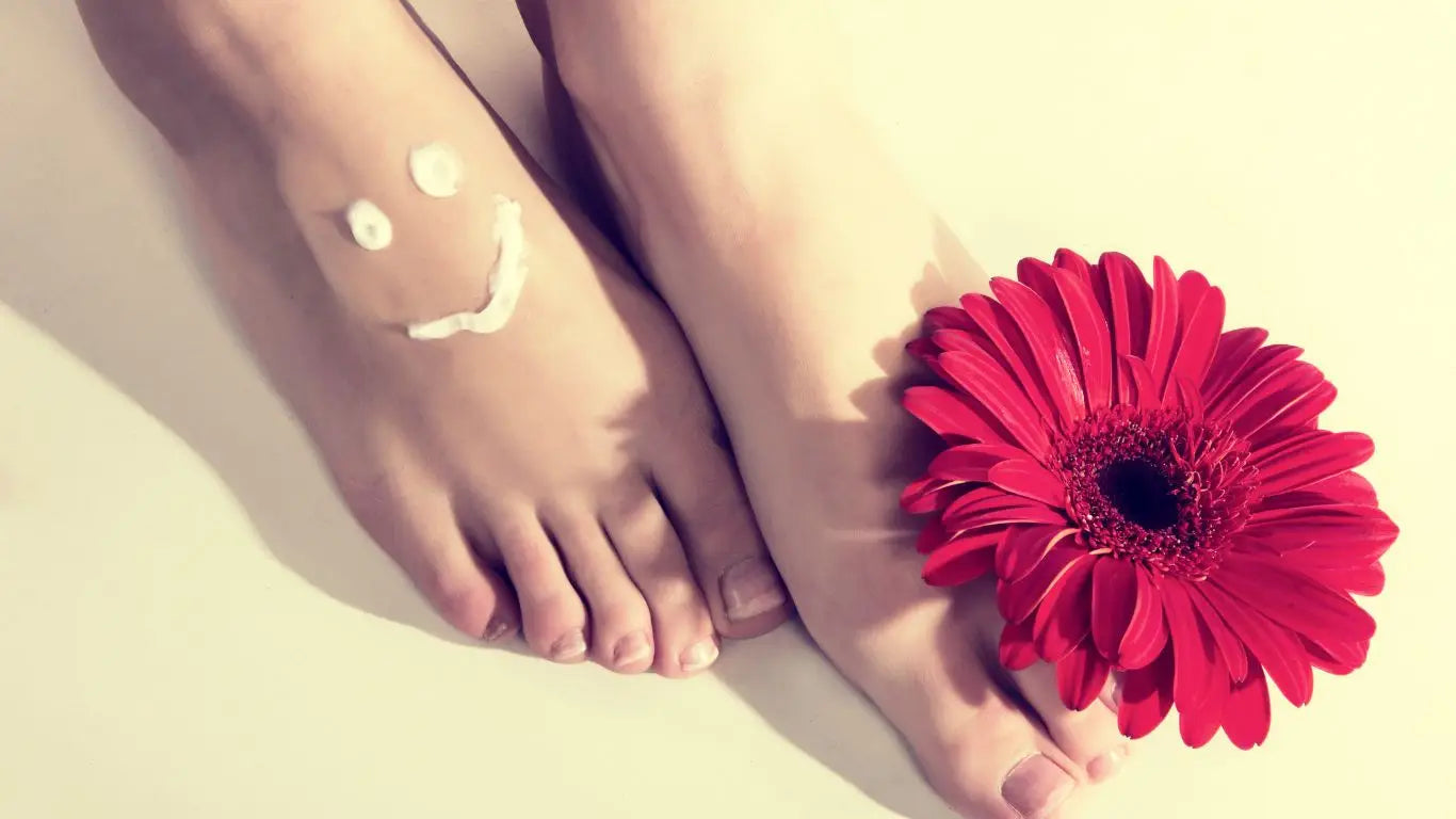 Paar Füße mit Gesichtssmile und roter Blume im Syis Podo Linie Fußpflege Collection
